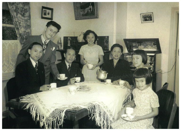 Multi-generational family portrait gathered around a tea table